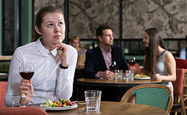 Frau sitzt alleine an Tisch im Restaurant