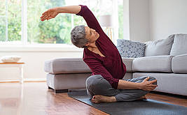 ältere Dame macht Yoga-Übung