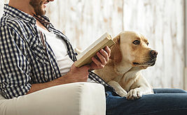 Mann liest seinem Hund vor