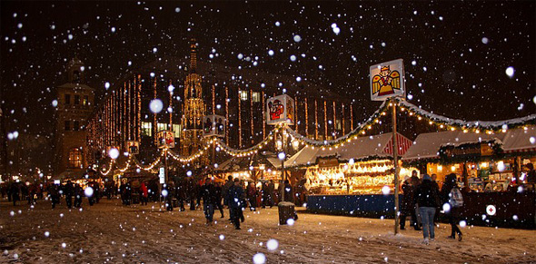 Nächtlicher Weihnachtsmarkt mit Schneefall